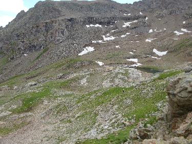 Descente de la montagne de CÃ©dÃ©ra par les pentes herbeuses. On aperÃ§oit le lac Ã  droite.