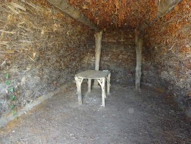 L&apos;intÃ©rieur de la cabane de bergers, faite de bois, de branchages et de terre